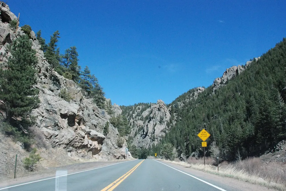 US-34 running between pine-covered rock walls in Big Thompson Canyon