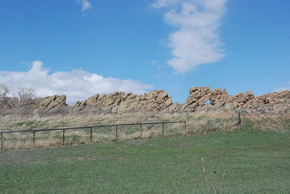 The jagged rock fin of the Devil's Backbone rising above a fenced field