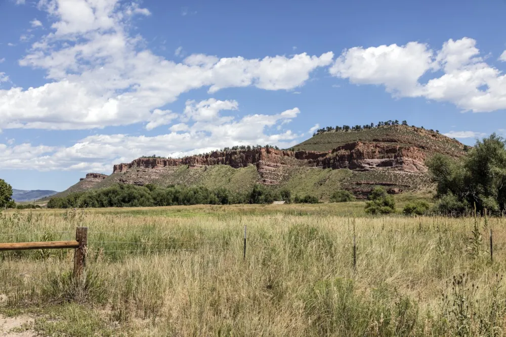 A red sandstone ridge above a grassy meadow along US-34 west of Loveland